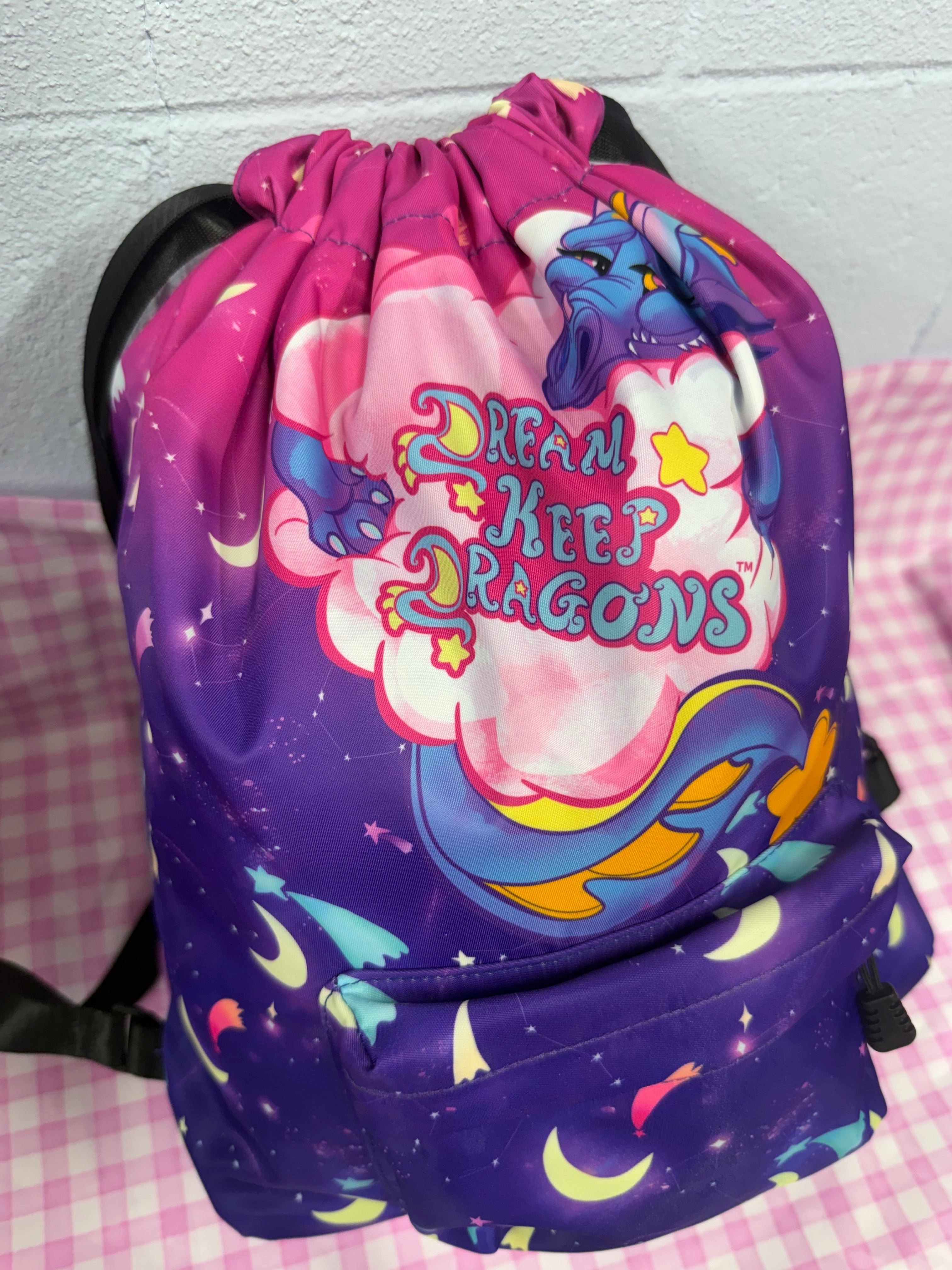 Backpack with dragon design and text on a checkered background